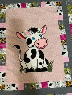 a patchwork quilt with a black and white cow on it