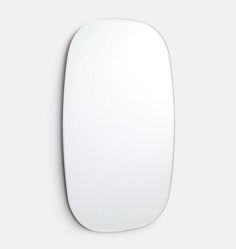 an oval shaped mirror on the wall with a white back ground and light grey background