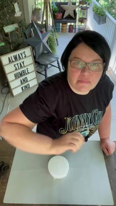 a woman sitting at a table making a funny face