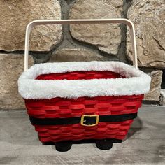 a basket with santa claus's hat on it sitting in front of a stone wall