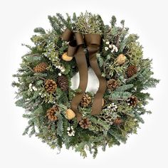 a christmas wreath with pine cones and evergreens