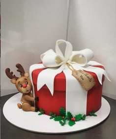 a decorated christmas cake with a reindeer holding a present