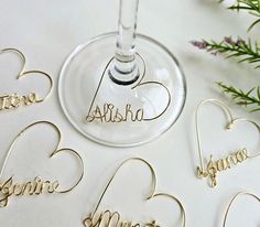 the wine glass has been decorated with names and hearts