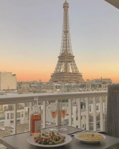 two plates of food on a table in front of the eiffel tower