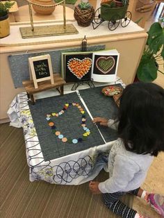 two children playing with an art project on the floor in front of a counter top