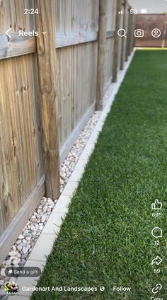 an image of a backyard with fake grass and rocks on the side of the fence