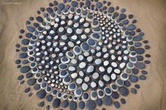 a circle made out of rocks sitting on top of a sandy beach