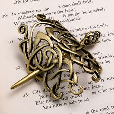 a book page with an antique style brooch on it