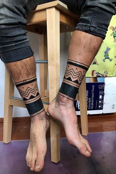 the legs and ankles of a man with tattoos on them