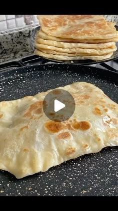 two flat breads sitting on top of a pan with one being cooked and the other is uncooked