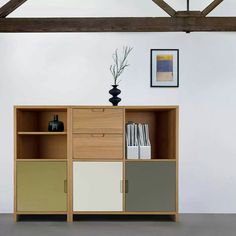 an empty room with a bookcase and vase on the floor in front of it