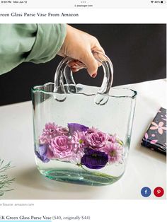 a hand is holding a clear bag with flowers in it