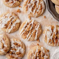 a bunch of cookies that are sitting on a piece of parchment paper with icing