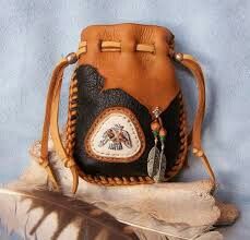 a brown leather purse sitting on top of a feather quill next to a blue wall