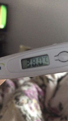 a thermometer is being held up to show an image of a person laying in bed