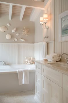 a bathroom with a bathtub, sink and towels hanging on the wall above it