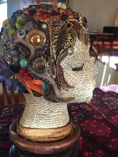 the head of a mannequin is covered in many different colored beads and jewels