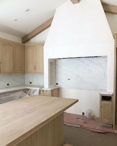 an unfinished kitchen with wood cabinets and white marble counter tops in the process of remodeling