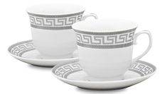 two white cups and saucers with greek designs