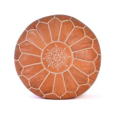 an orange leather poufle with white beading on the top and bottom, sitting against a white background