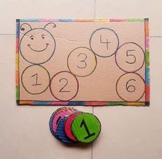 a child's activity board with numbers and shapes on the floor next to it