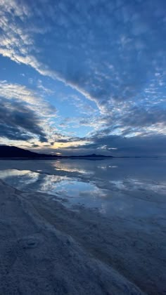 the sky is reflected in the still water on the beach at sunrise or sunset time