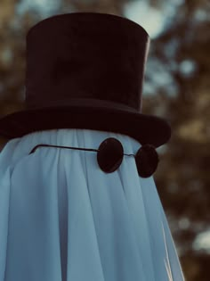 a close up of a person wearing a top hat and dress with buttons on it