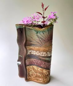 a vase with flowers in it sitting on a white table next to a planter