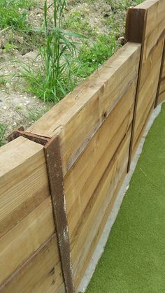 a close up of a wooden fence with grass in the background