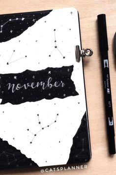 a notebook with the word november written on it next to a black pen and mouse