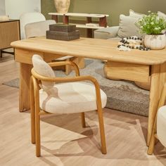 a wooden table with two chairs and a plant on top of it in a living room