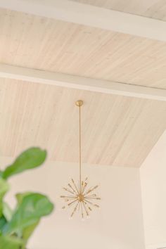 a chandelier hanging from the ceiling in a room with white walls and wood paneling