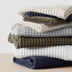 folded towels stacked on top of each other in various colors and patterns, with one folded