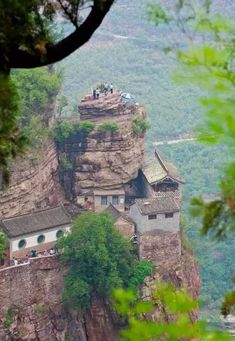 people are standing on the top of a cliff