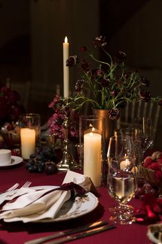 the table is set with candles, plates and napkins