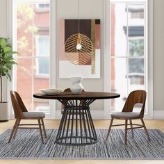 a dining room table with chairs and a rug in front of the window, next to a potted plant