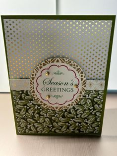 a close up of a greeting card with gold foil on the front and green background