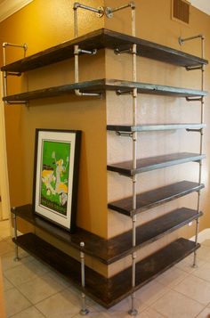 an empty shelf in the middle of a room with shelves on each side and a framed poster hanging above it