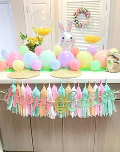 a table with balloons, tassels and bunnies on it