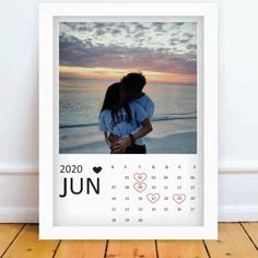 a photo frame with a couple hugging on the beach in front of an ocean sunset