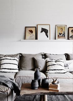 a living room filled with lots of furniture and pictures on the wall above it's coffee table