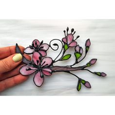 a hand holding a piece of art made out of paper with pink flowers on it