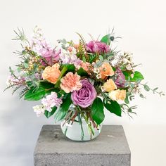 a vase filled with lots of different colored flowers