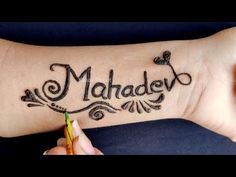 a woman's arm with the word maha written on it and a pen in her hand