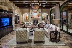 a living room filled with lots of furniture and a flat screen tv mounted to the wall