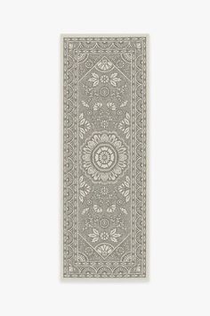 a gray rug with an intricate design on the front and back side, hanging from a wall