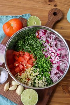 the ingredients for this dish are neatly arranged in a large metal bowl on a wooden cutting board