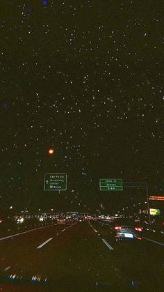 the night sky is filled with stars and street signs