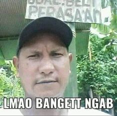 a man wearing a hat standing in front of a sign that says, i amo banget ngab