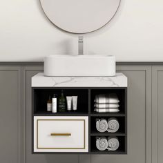 a bathroom sink sitting under a mirror next to a counter top with towels on it